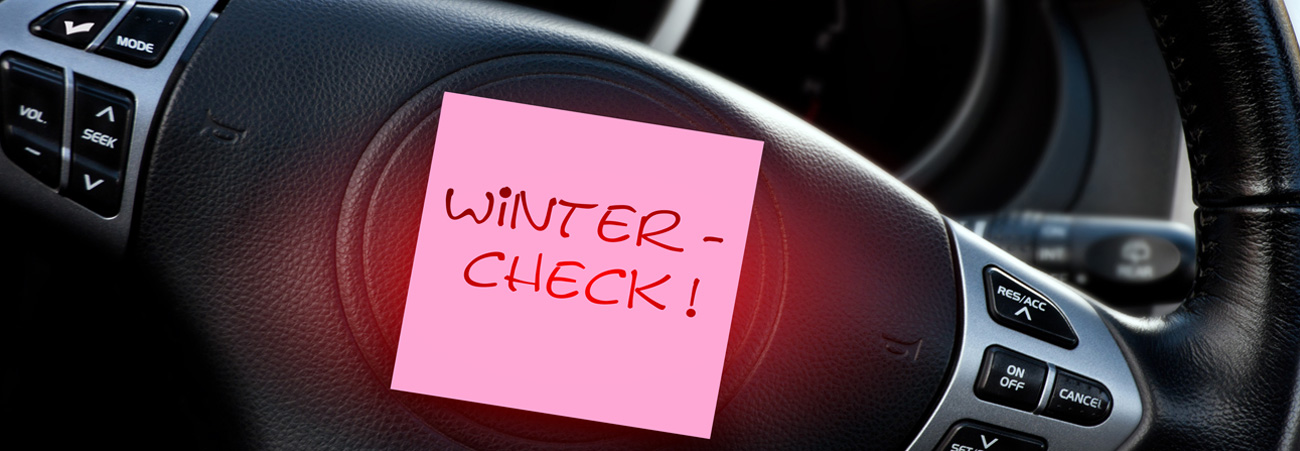 Ein Post-It Winter-Check klebt am Armaturenbrett eines Autos.