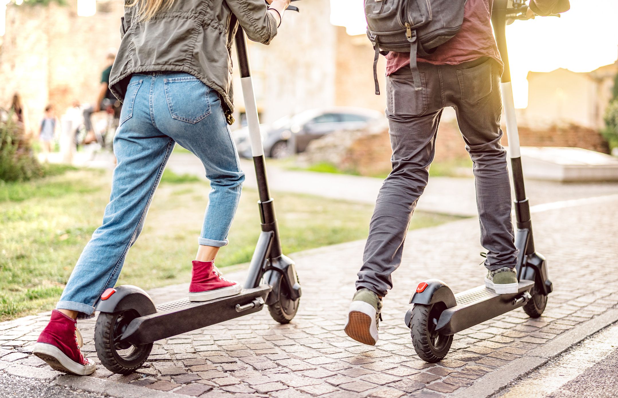 zwei Personen fahren nebeneinander E-Scooter