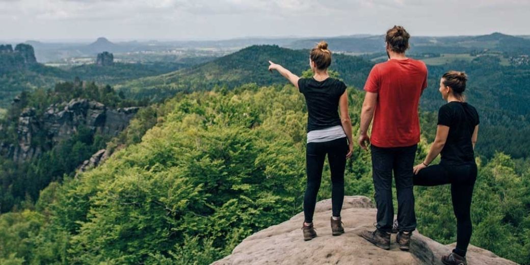 Drei Wanderer genießen den Ausblick auf die Felsenlandschaft der Sächsischen Schweiz
