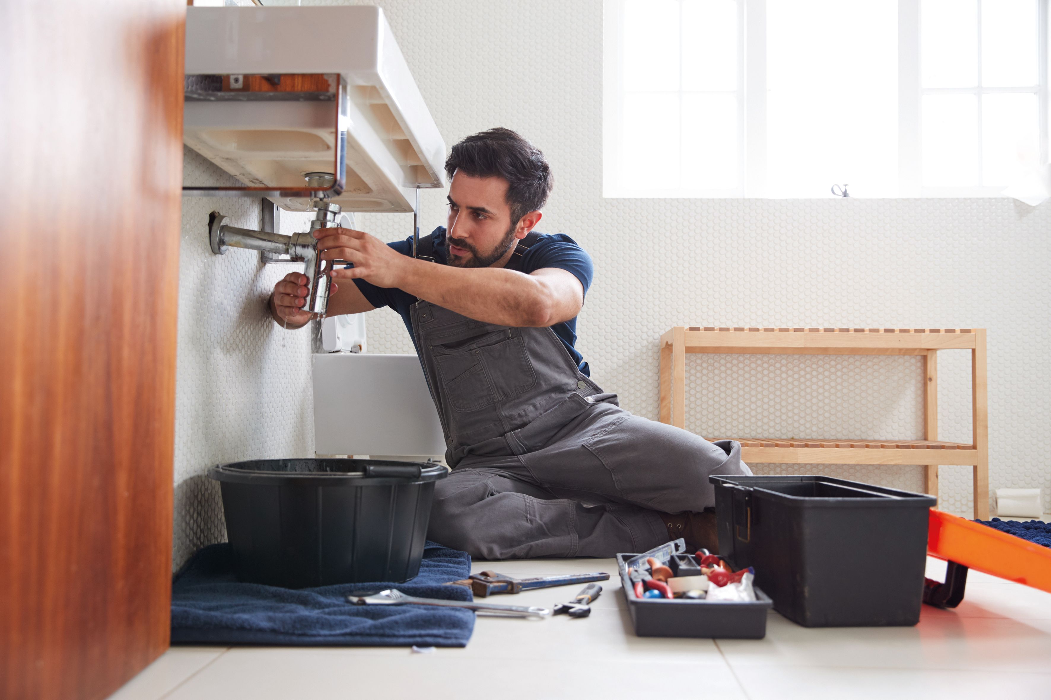 Klempner unter dem Waschbecken bei der Arbeit