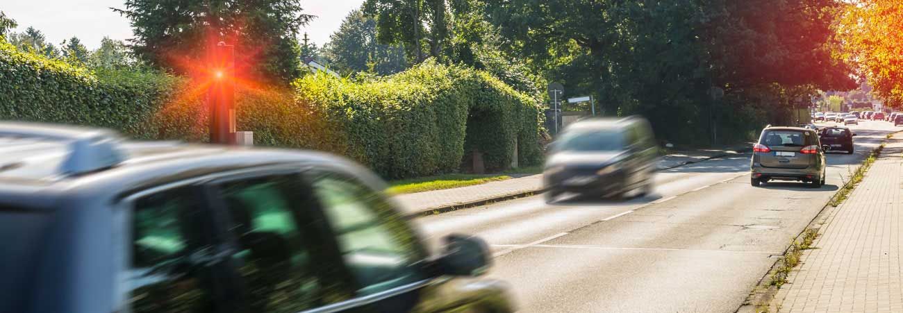 Radarfalle löst auf Straße mit Auto mit rotem Blitz aus