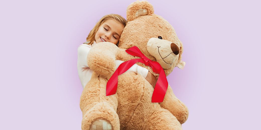 Kind umarmt einen großen Teddybären als Symbol für Ausbildungsversicherung, Kinderabsicherung und finanzielle Vorsorge.