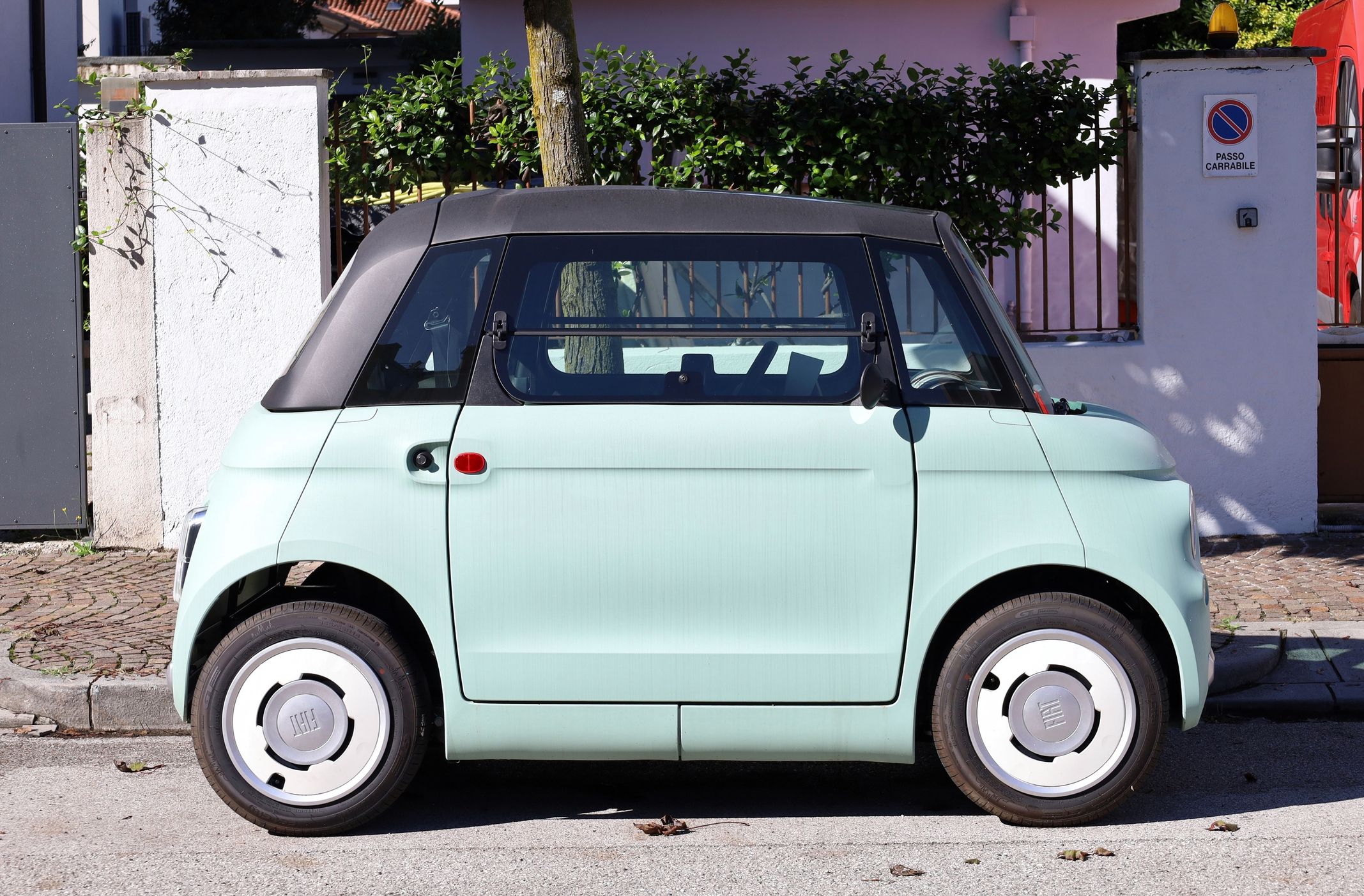 ein hellblaues Microcar steht auf der Straße