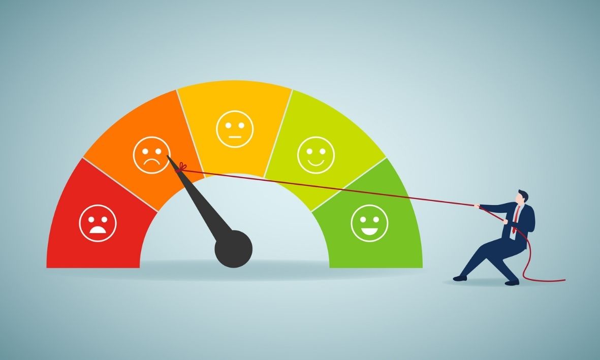 Illustration einer Zufriedenheitsskala von rot bis grün; eine Person zieht mit einem Seil den Zeiger aus dem roten Bereich in Richtung grün