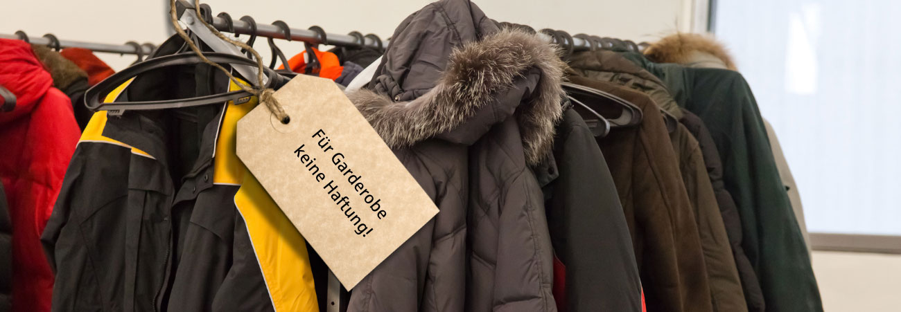 Jacken hängen an einer Garderobenstange mit der Aufschrift "Für Garderobe keine Haftung"
