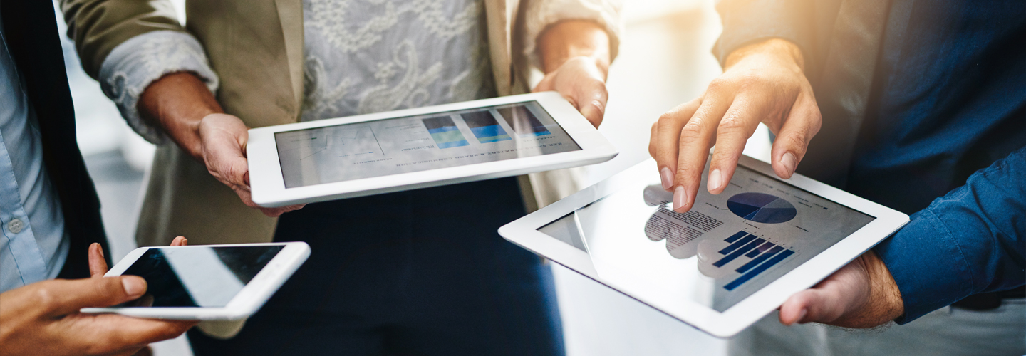 Team arbeitet mit Tablets und Smartphones an Datenanalysen