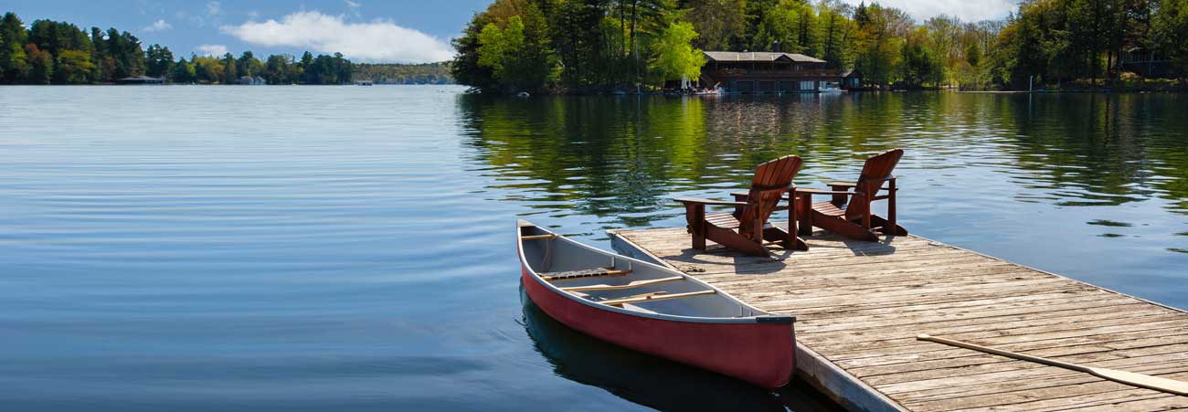 ein Paddelboot liegt am Holzsteg am See