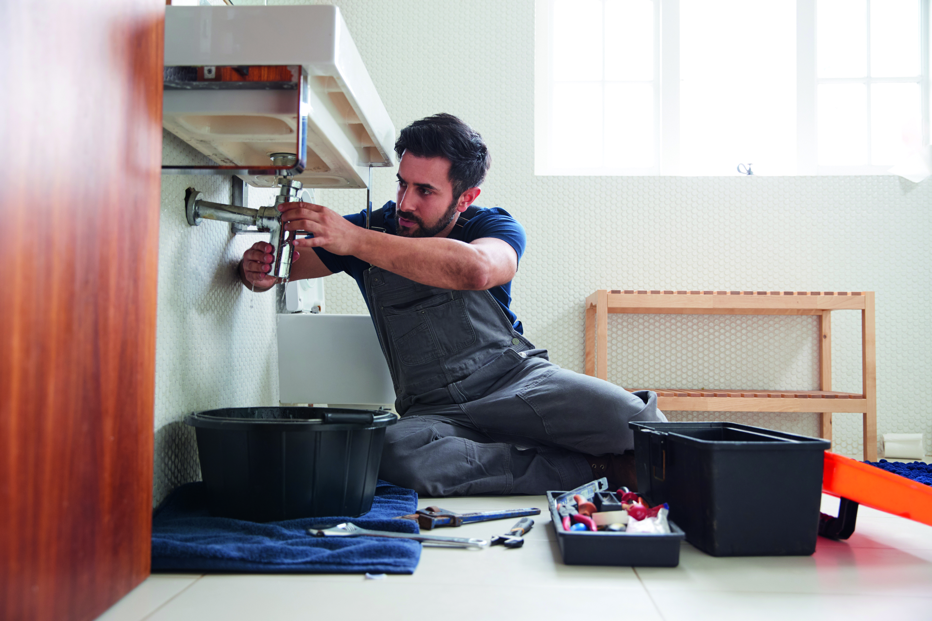 Klempner unter dem Waschbecken bei der Arbeit