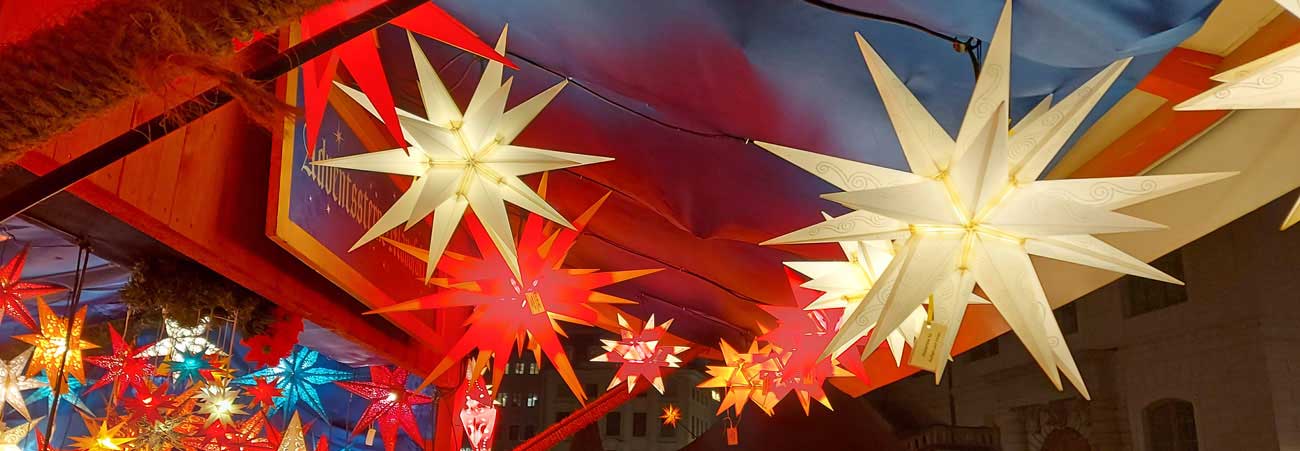 Herrenhuter Sterne hängen an einem sächsischen Weihnachtsmarktstand