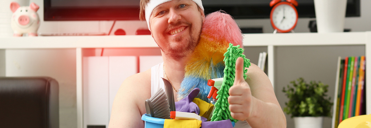 lächelnder Mann hält einen Eimer voller Putzutensilien