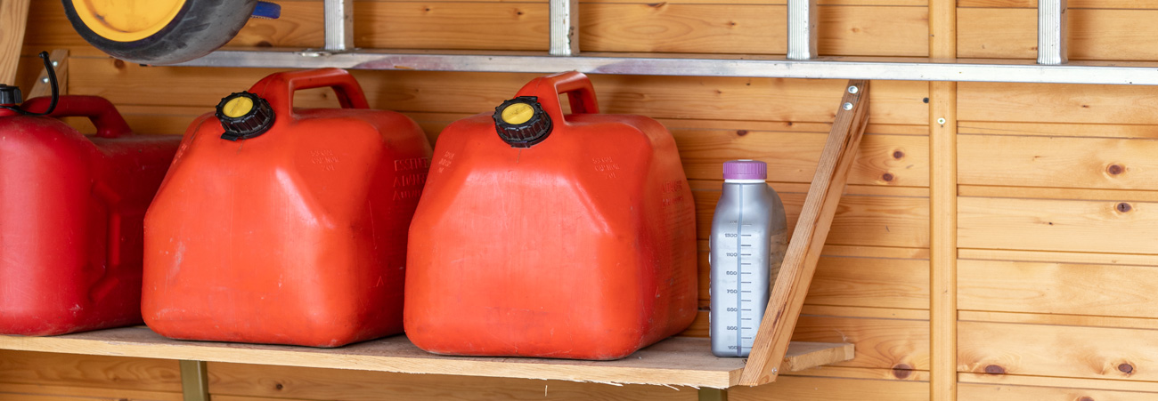 drei rote Kanister stehen auf einem Regalbrett in der Garage