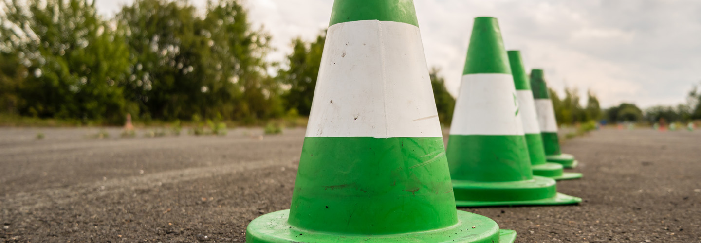 Grüne und weiße Verkehrskegel auf einem Übungsplatz
