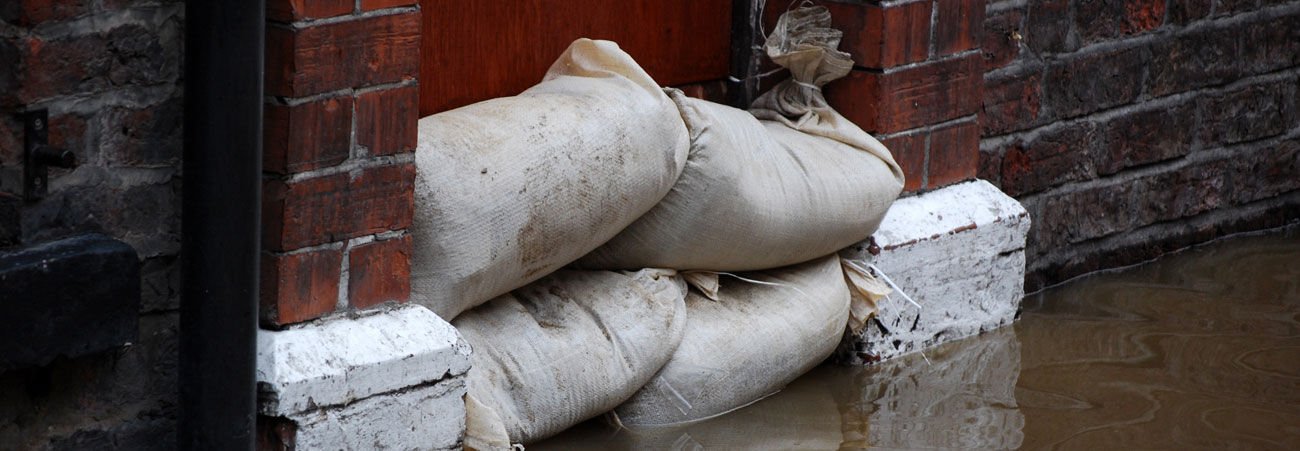 Sandsäcke sind bei Hochwasser vor der Tür eines Gebäudes gestapelt
