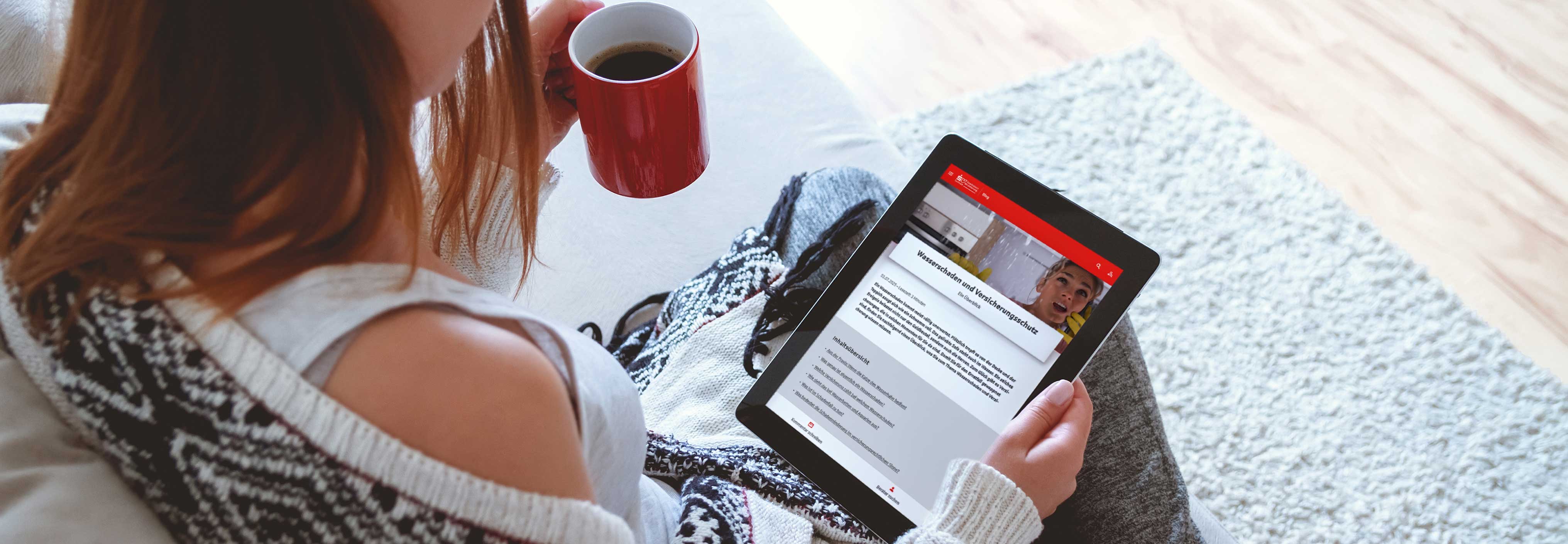 Junge Frau liest auf Tablet einen Blogartikel der Sparkassen-Versicherung Sachsen