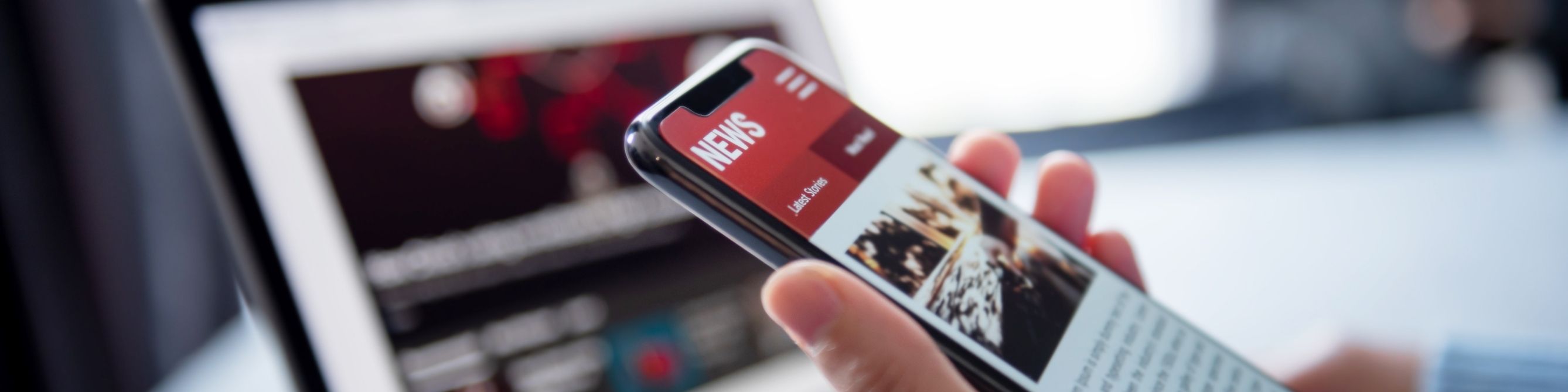 Laptop und Smartphone mit Newsmeldung
