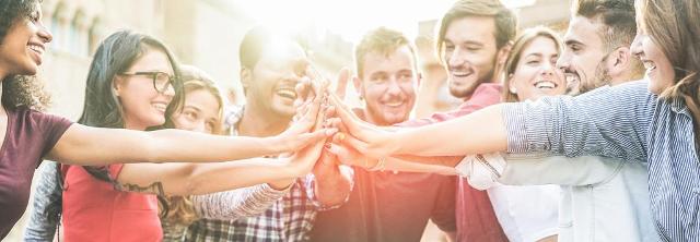 Junge Menschen legen ihre Hände ineinander