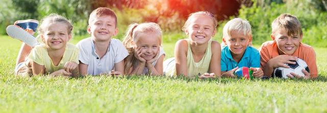 Viele Kinder mit Fußball auf einer Wiese