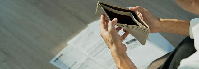 Zwei Hände klappen eine leere Geldbörse auf