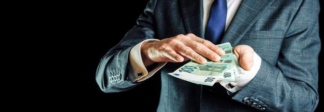 Mann mit Geldbuendel in der Hand
