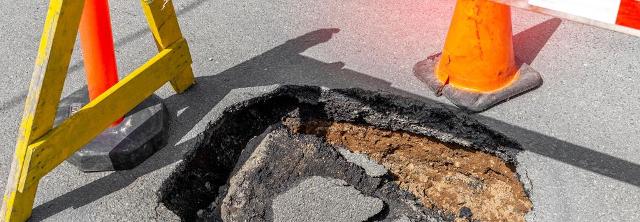 Schlagloch auf Straße ist abgesichert