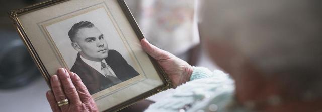 Witwe schaut auf Foto des verstorbenen Gatten
