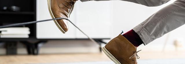 Mann stolpert über Kabel