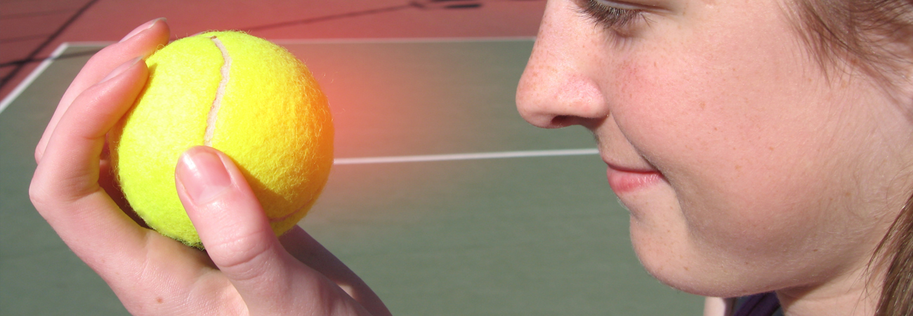 Frau hält einen Tennisball in der Hand 