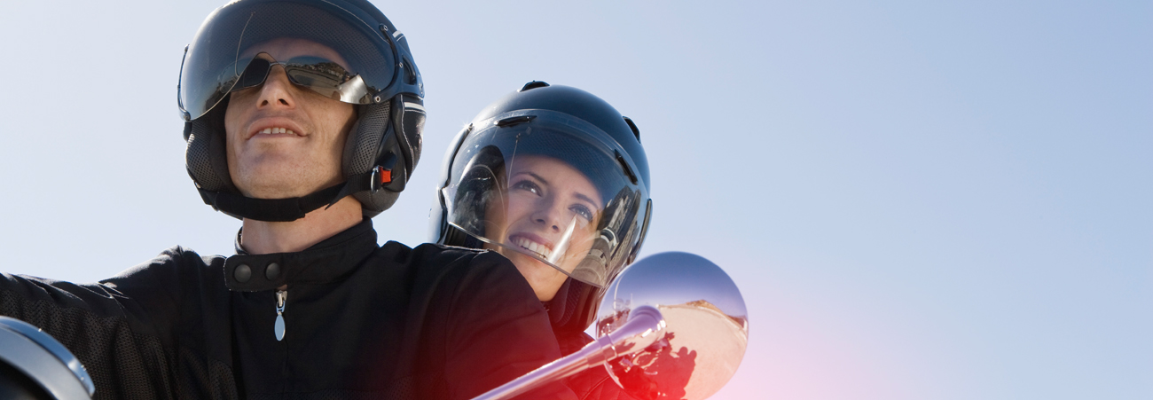 Paar mit Helmen sitzt auf Motorrad