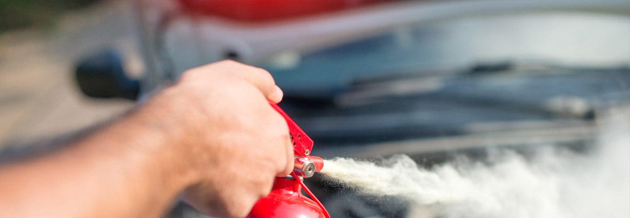 Autobrand wird mit Handfeuerlöscher gelöscht