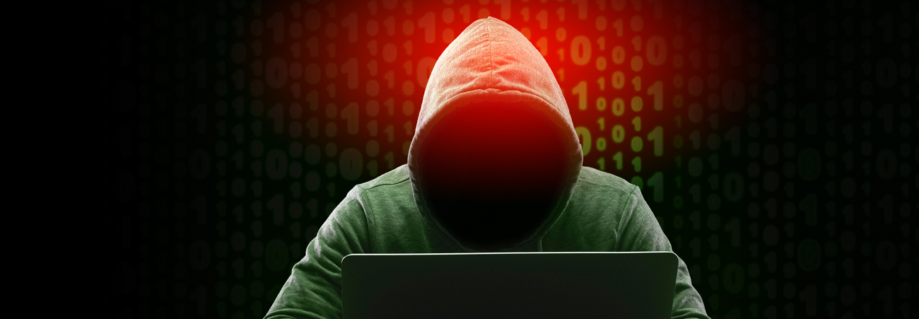Cyberkrimineller sitzt vor Rechner