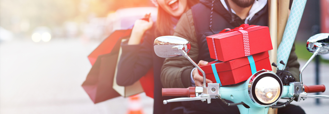 Paar auf Moped mit Geschenkpäckchen