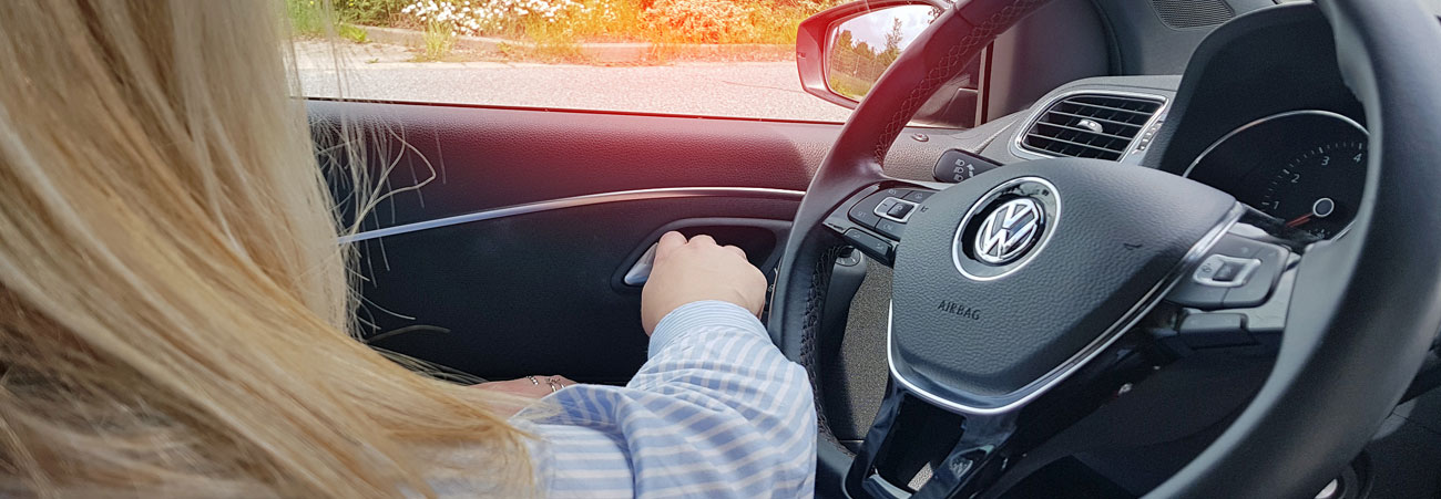 Junge Frau öffnet von innen die Fahrertür des Autos