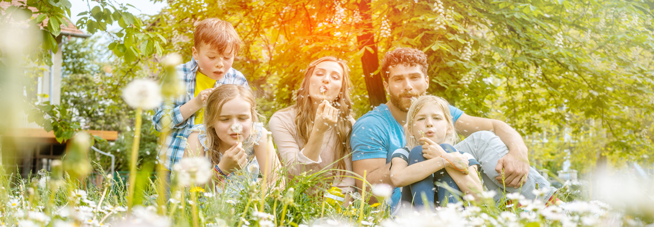 Familie auf Wiese mit Pusteblumen