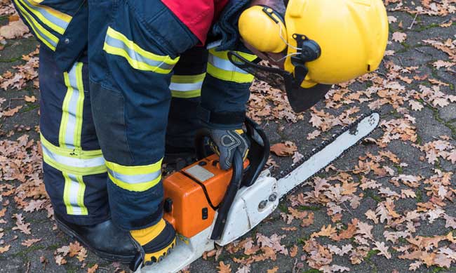 Feuerwehrmann mit Kettensäge