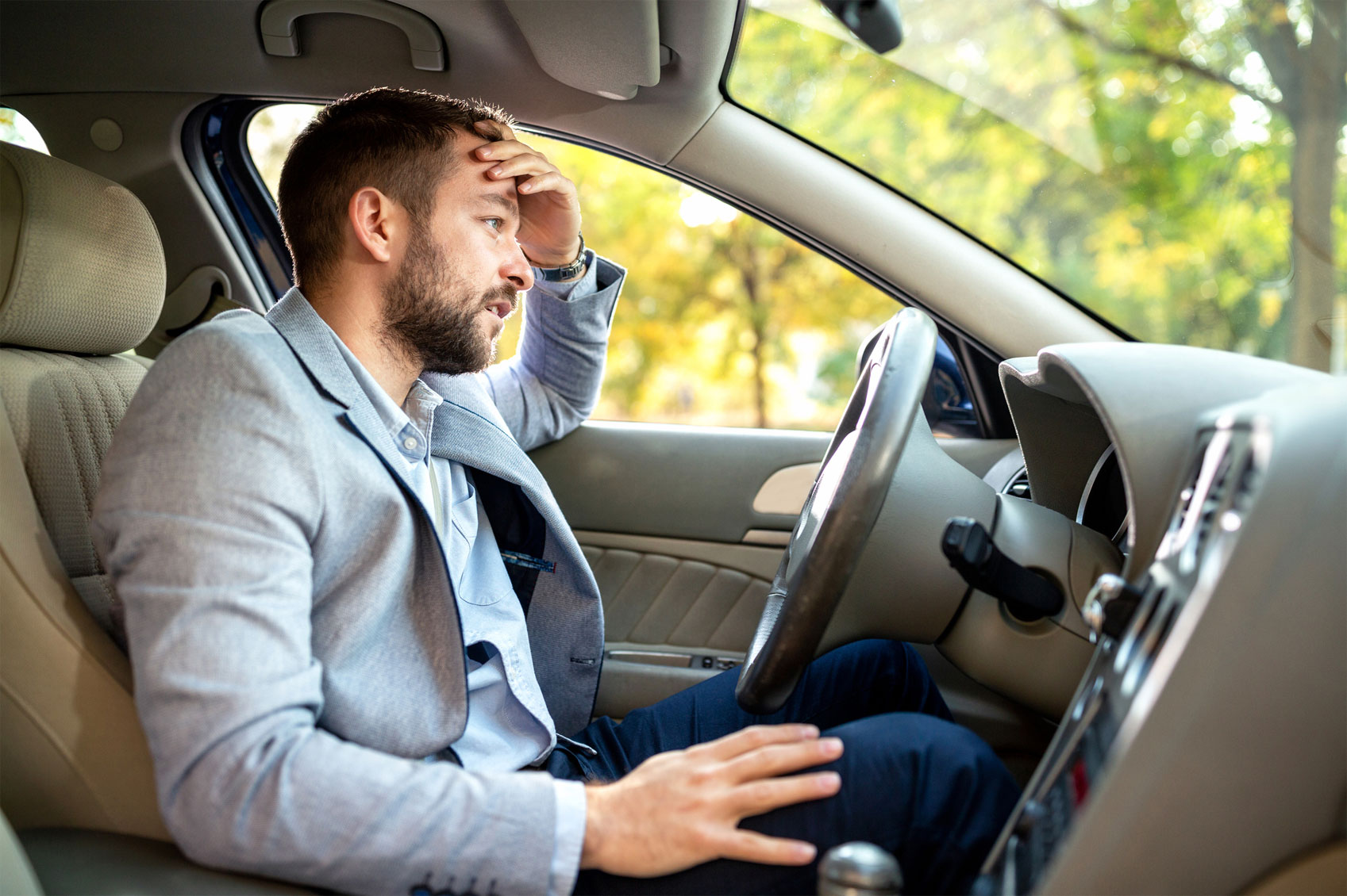 Mann sitzt genervt im Auto