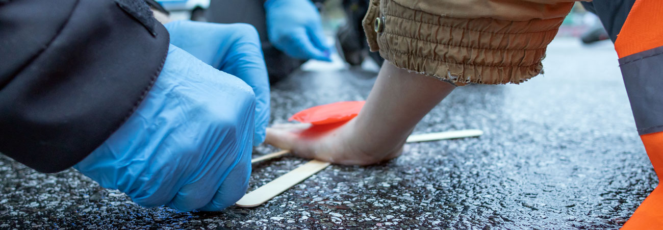 Polizisten lösen angeklebten Umweltaktivisten von der Straße