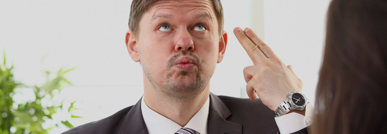 Businessmann verdreht genervt die Augen
