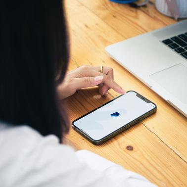 Frau schaut auf Smartphone mit Paypalapp