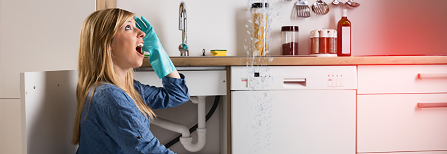 Frau sieht Wasser von der Decke tropfen