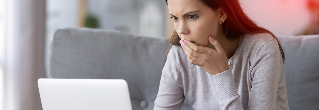 Mädchen schaut entsetzt in Laptop