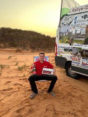 Rallyefahrer mit einem verpackten Stollen in der Hand