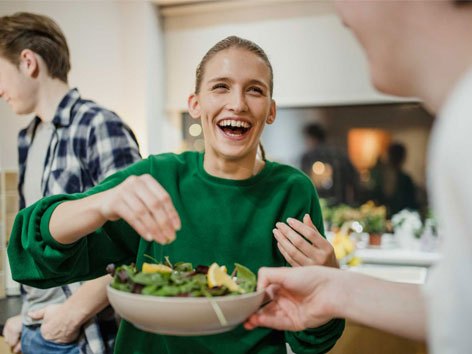 Freunde bereiten gemeinsam einen Salat zu