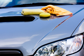 Pflegeutensilien für Autolack liegen auf Motorhaube