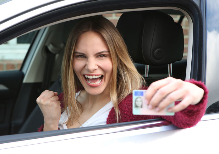 Junge Frau mit Führerschein in der Hand
