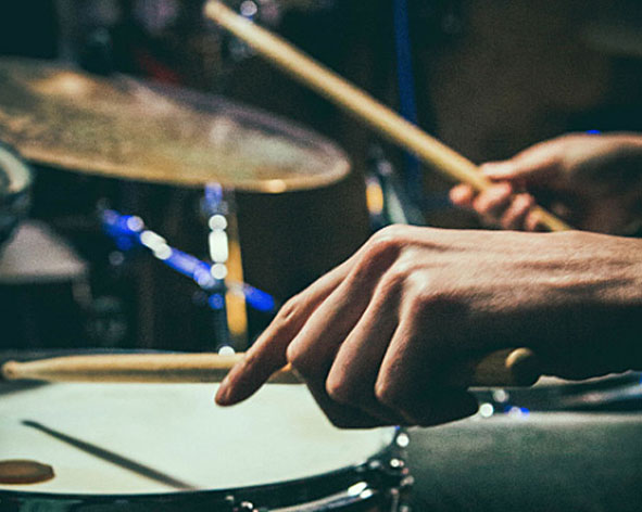 Drummer hat Drumsticks in der Hand und spielt Schlagzeug