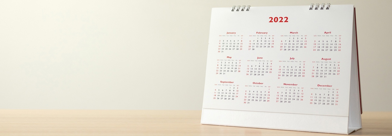 Kalender mit Jahresübersicht 2022 steht auf Schreibtisch.
