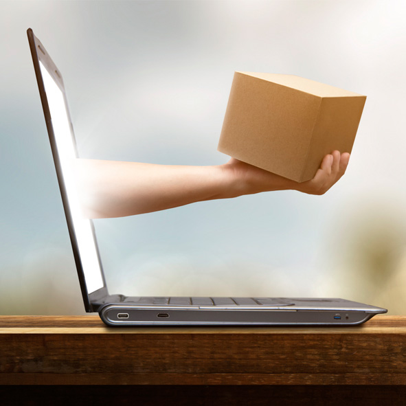 Hand mit Paket ragt aus Laptop