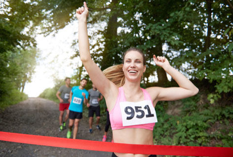 Junge Läuferin glücklich im Zieleinlauf