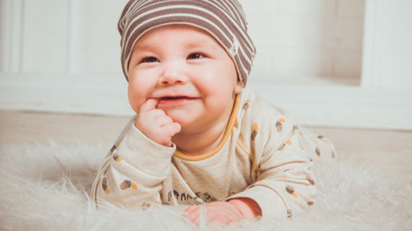 lachendes Baby mit geringelter Mütze