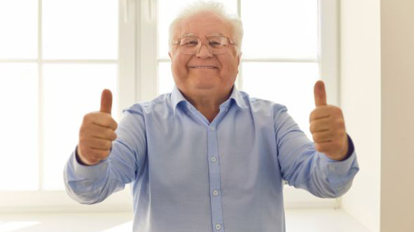 Senior macht Geste Daumen nach oben mit beiden Händen